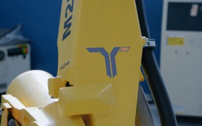 Braccio robotico Fanuc industriale giallo con logo Taurus Automation per automazione meccatronica.